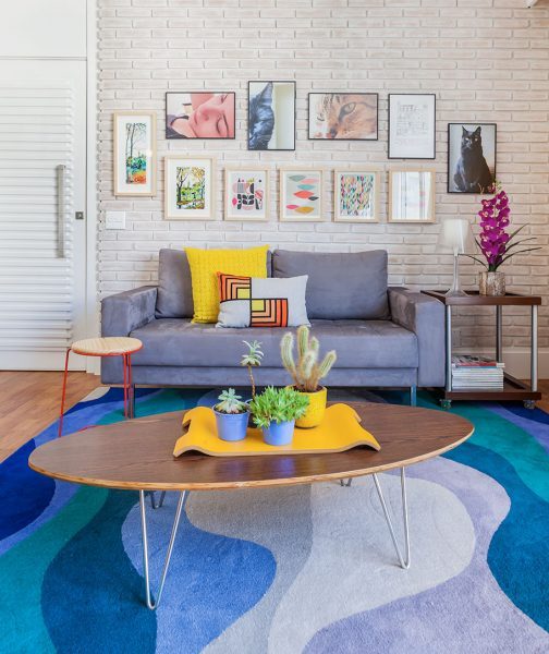 sala de estar com tijolinho aparente e tapete colorido