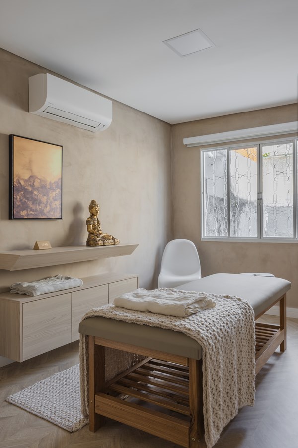 sala de clinica com maca no centro e paineis de madeira