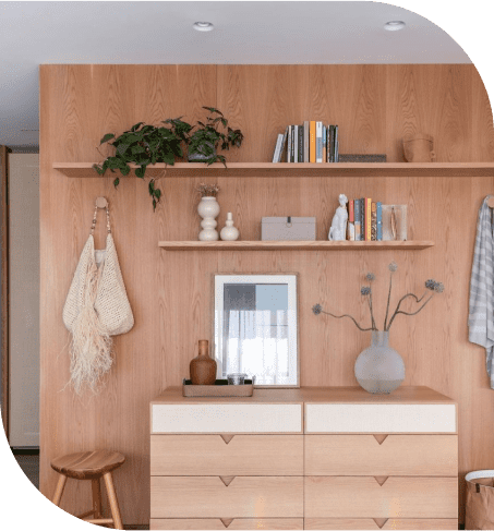 Comoda e painel de madeira com decorações de flores e livros