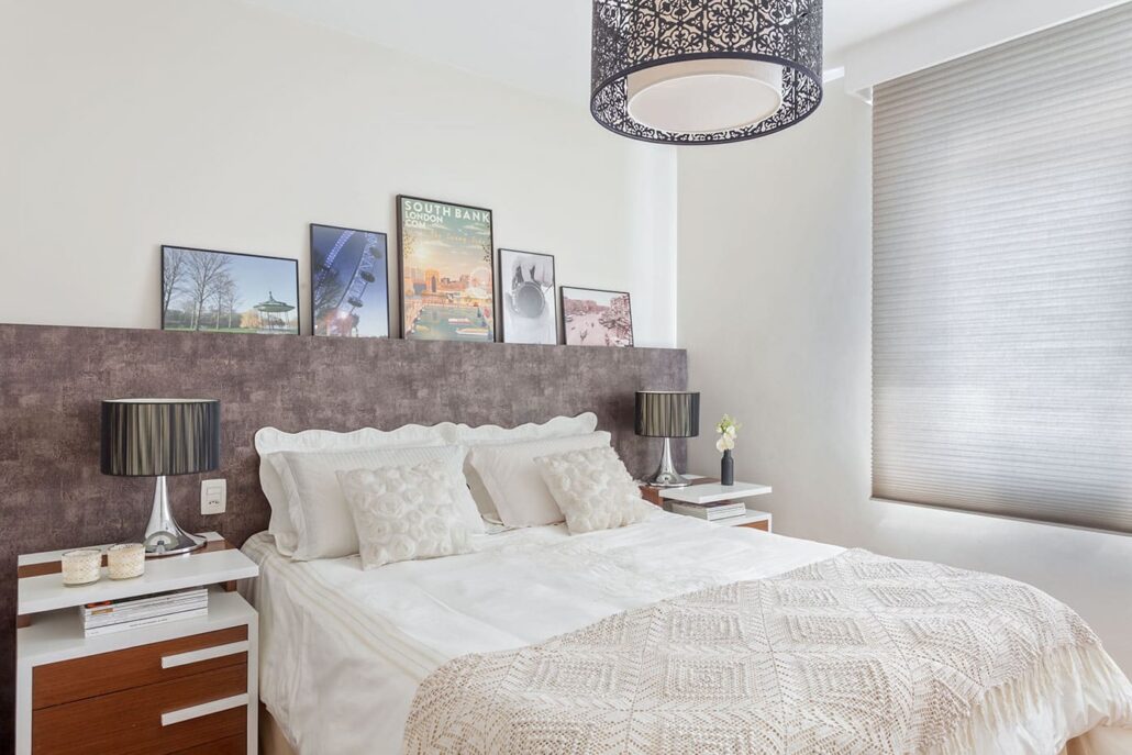 quarto com cabeceira com quadros em cima