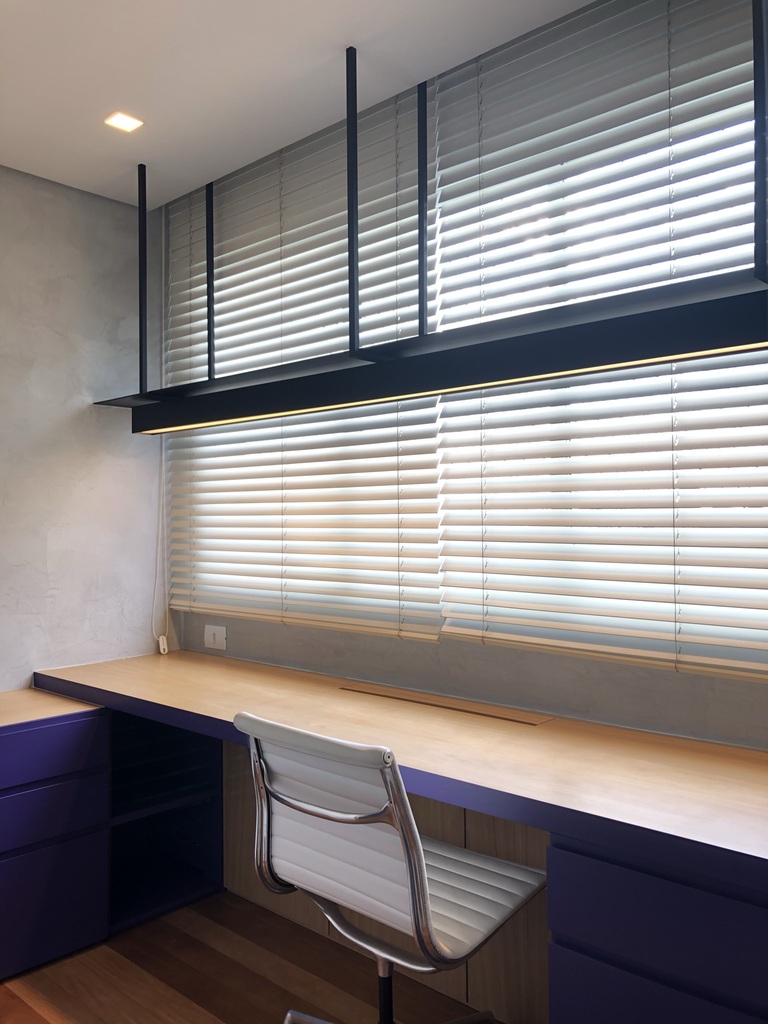 escritório com mesa grande e cadeira de frente a janela