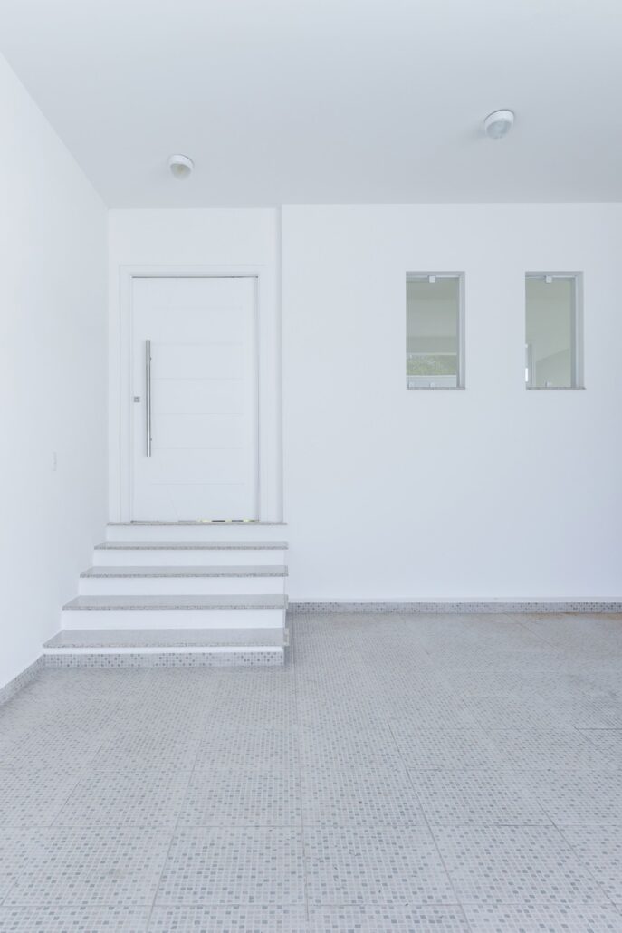 area interna com escadas para porta branca