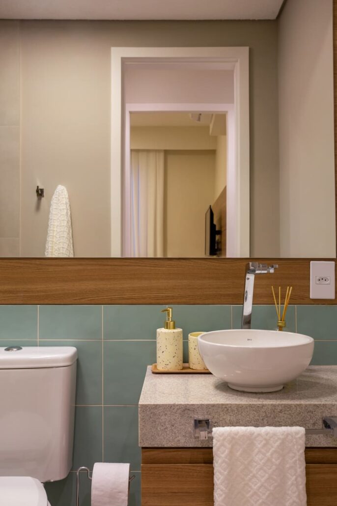 banheiro com espelho grande e decorações em madeira