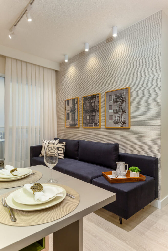 sala com sofá escuro com vista para para mesa da cozinha