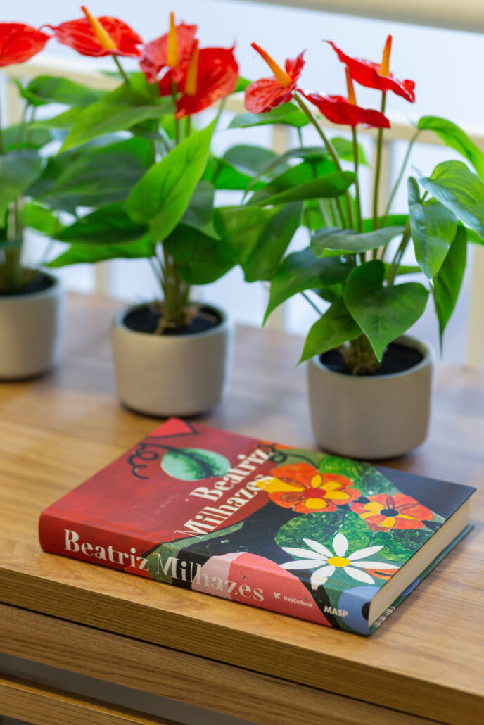 mesa com livro e vasos com plantas