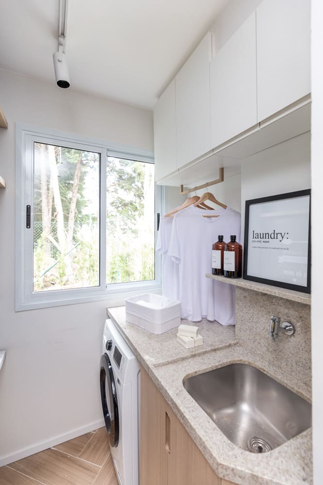lavanderia com roupas brancas penduradas em cima da maquina de lavar