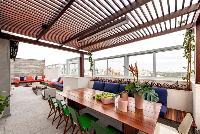 cobertura com mesa de madeira com maças verdes ao centro e decoração de plantas