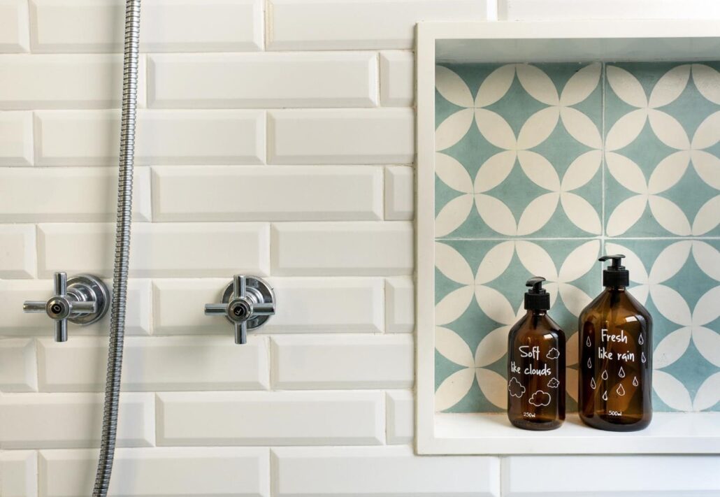 banheiro com placa de tijolo branco e espaço para produtos de higiene