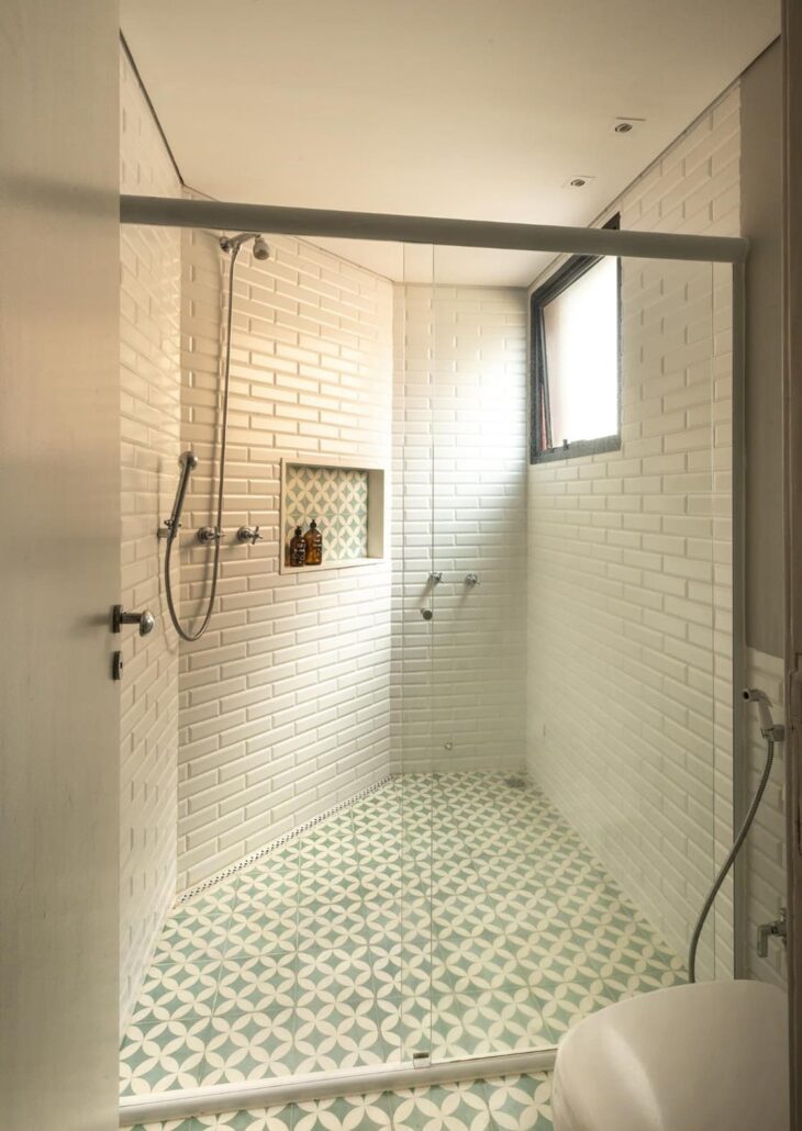 banheiro com placa de tijolo branco e espaço para produtos de higiene