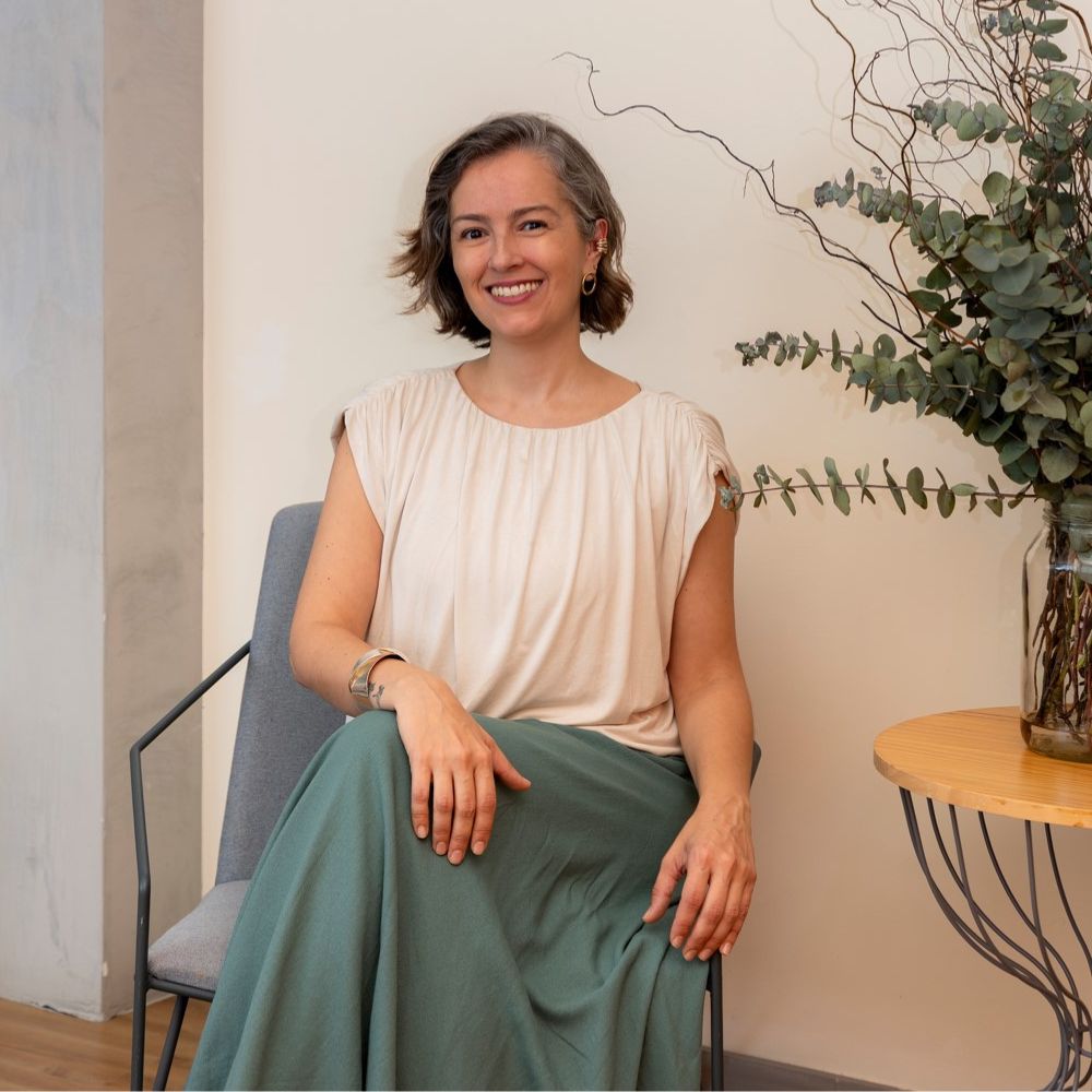 Carol Pontes Arquiteta entada em uma cadeira elegante